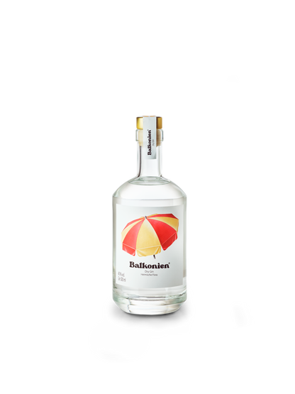 Klare Glasflasche mit weißem Etikett, darauf ein rot-gelber Sonnenschirm und der Schriftzug 'Balkonien'. Darin befindet sich der Heimische Flora Dry Gin von Balkonien.
