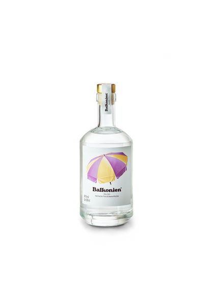Klare Glasflasche mit weißem Etikett, darauf ein lila-gelber Sonnenschirm und der Schriftzug 'Balkonien'. Darin befindet sich der Heimische Flora & Beerenfrüchte Dry Gin von Balkonien.